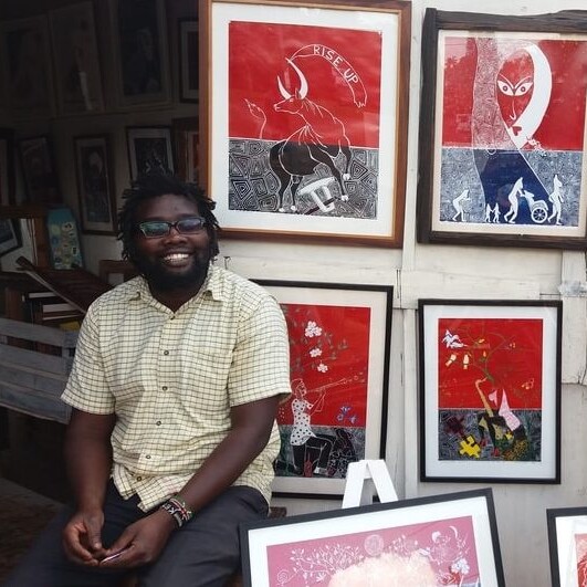 A proud artist with his work - George Ongeri beams alongside his masterpieces at his shop, The Art Kiosk