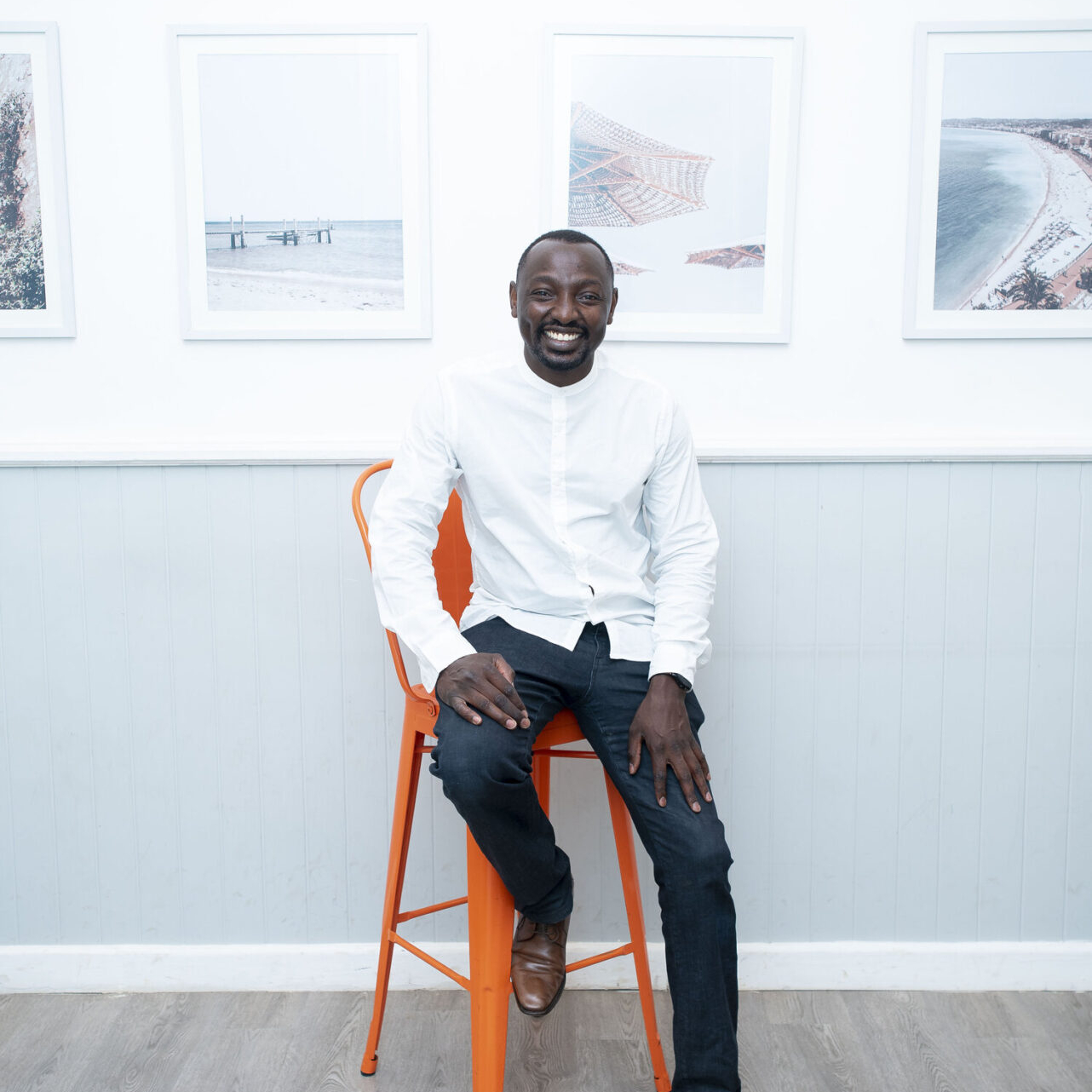 A photo of Mukurima Muriuki sitting on an orange chair.