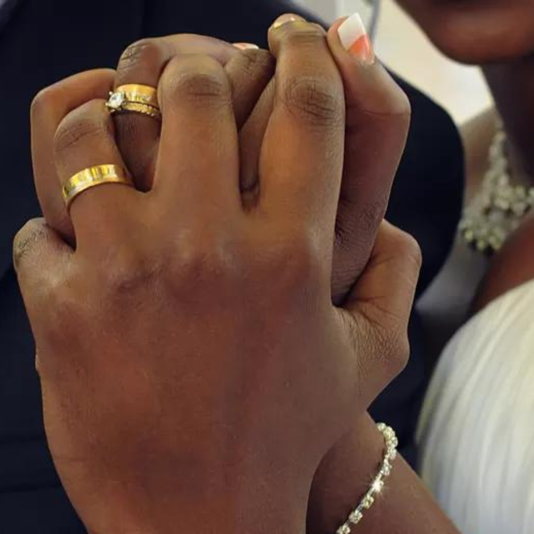 Wedding rings on the hands of a newlywed couple.